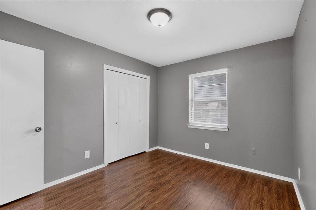 101 Spinner Circle, DeSoto, TX 75115 Wood-finish flooring, neutral gray wall tones, white trim, and a window with blinds