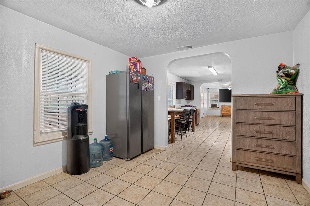 5800 Dallas Avenue, Fort Worth, TX 76112 Arched doorway entry, tiled flooring, window with blinds, recessed lighting, wood-finish cabinetry