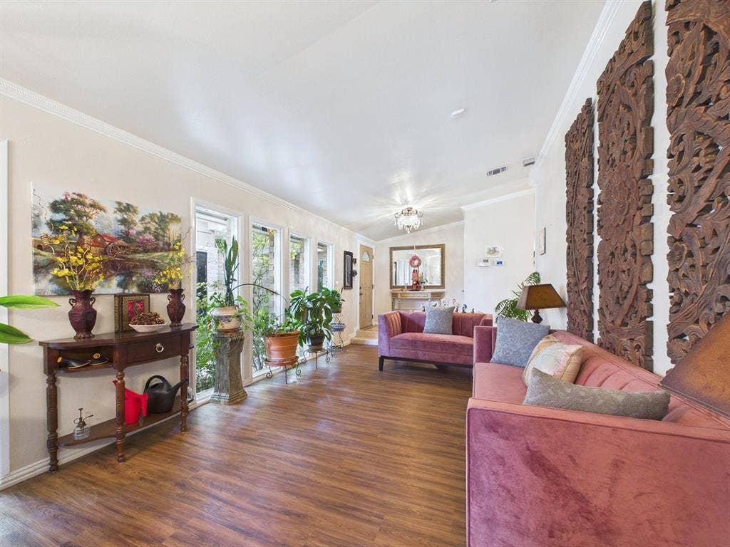 9335 Whittenburg Gate, Dallas, TX 75243 Wood-finish flooring throughout, crown molding, multiple windows, and a decorative overhead light fixture