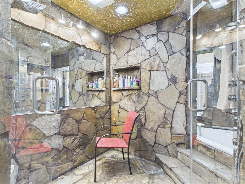 9335 Whittenburg Gate, Dallas, TX 75243 Full stone wall and flooring, built-in recessed shelf, glass-enclosed shower, wall-mounted shower system