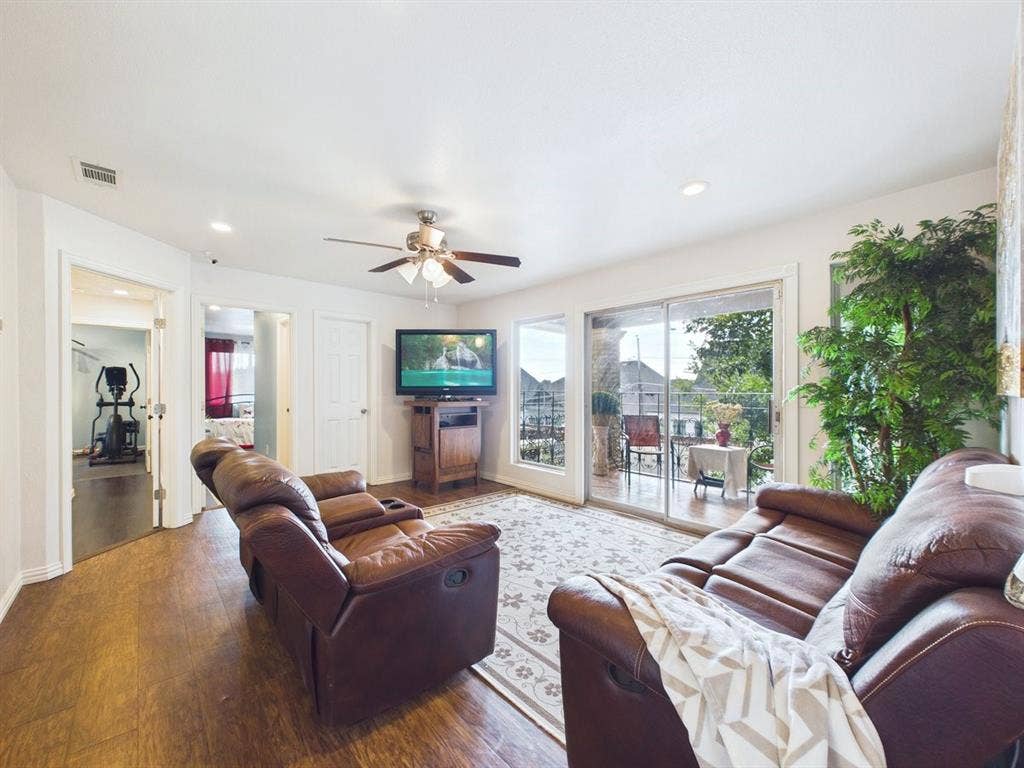 9335 Whittenburg Gate, Dallas, TX 75243 Wood-finish flooring throughout, ceiling fan with integrated lighting, recessed lighting, and sliding glass doors opening to an exterior balcony