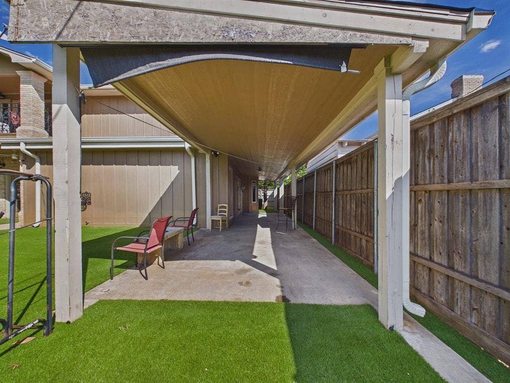 9335 Whittenburg Gate, Dallas, TX 75243 Covered walkway with a sun shade, artificial turf, concrete pathway, and wood panel fencing