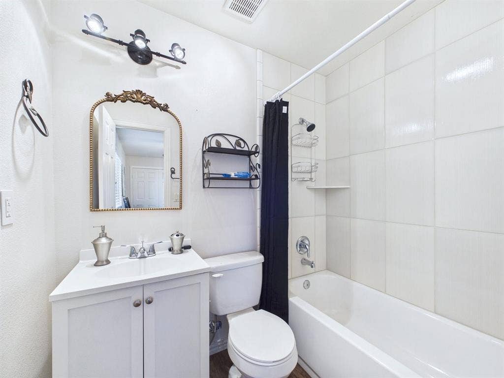 9335 Whittenburg Gate, Dallas, TX 75243 White vanity with cabinet storage, a chrome faucet, and an ornate mirror