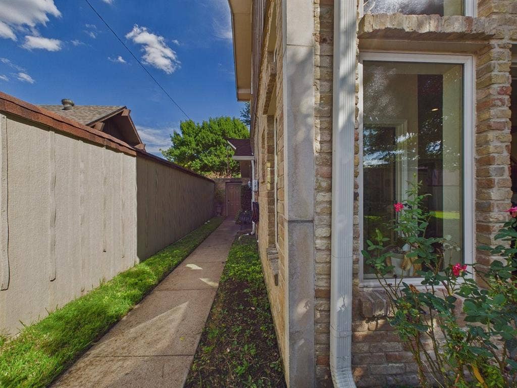 9335 Whittenburg Gate, Dallas, TX 75243 Brick exterior with stone accents, framed window, and landscaped perimeter