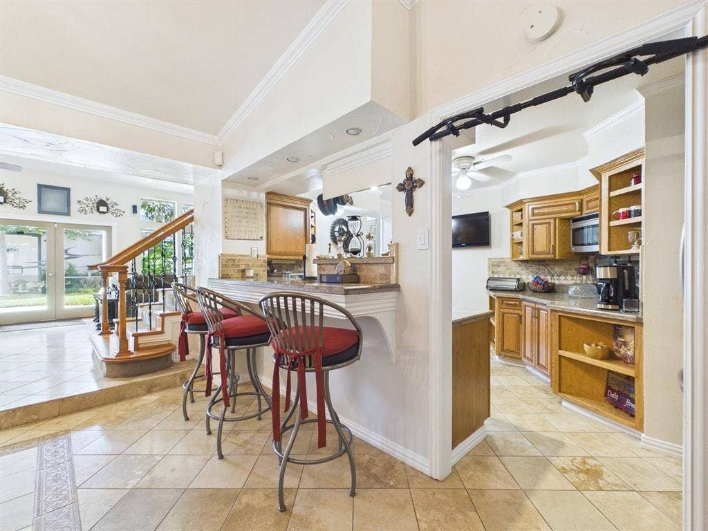 9335 Whittenburg Gate, Dallas, TX 75243 Kitchen with wood cabinetry, granite countertops, and tile backsplash