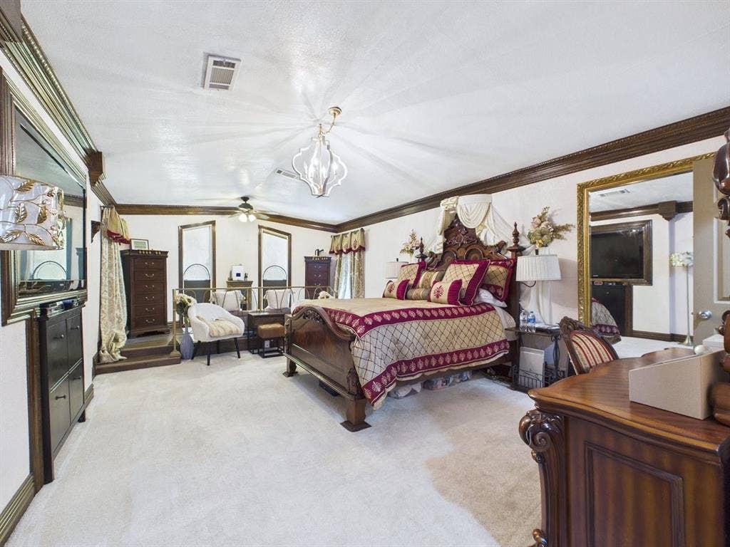 9335 Whittenburg Gate, Dallas, TX 75243 Expansive room featuring light-toned carpeting, decorative crown molding, and a tray ceiling with a central chandelier