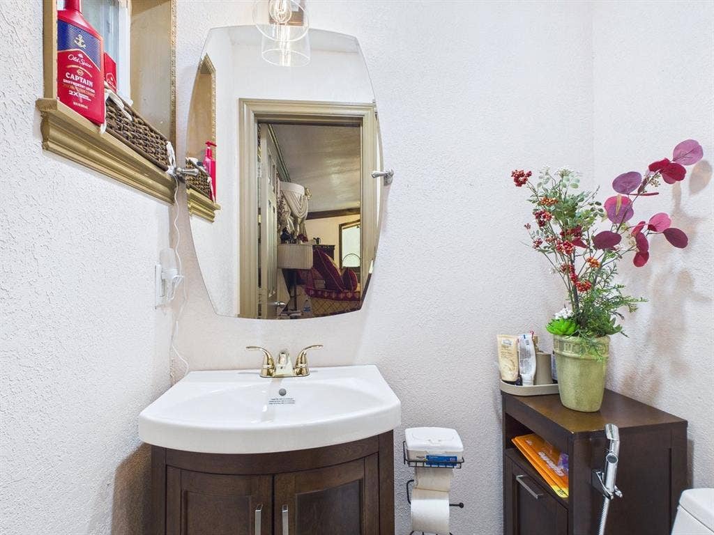 9335 Whittenburg Gate, Dallas, TX 75243 Corner vanity with a white basin and brass-finish faucet