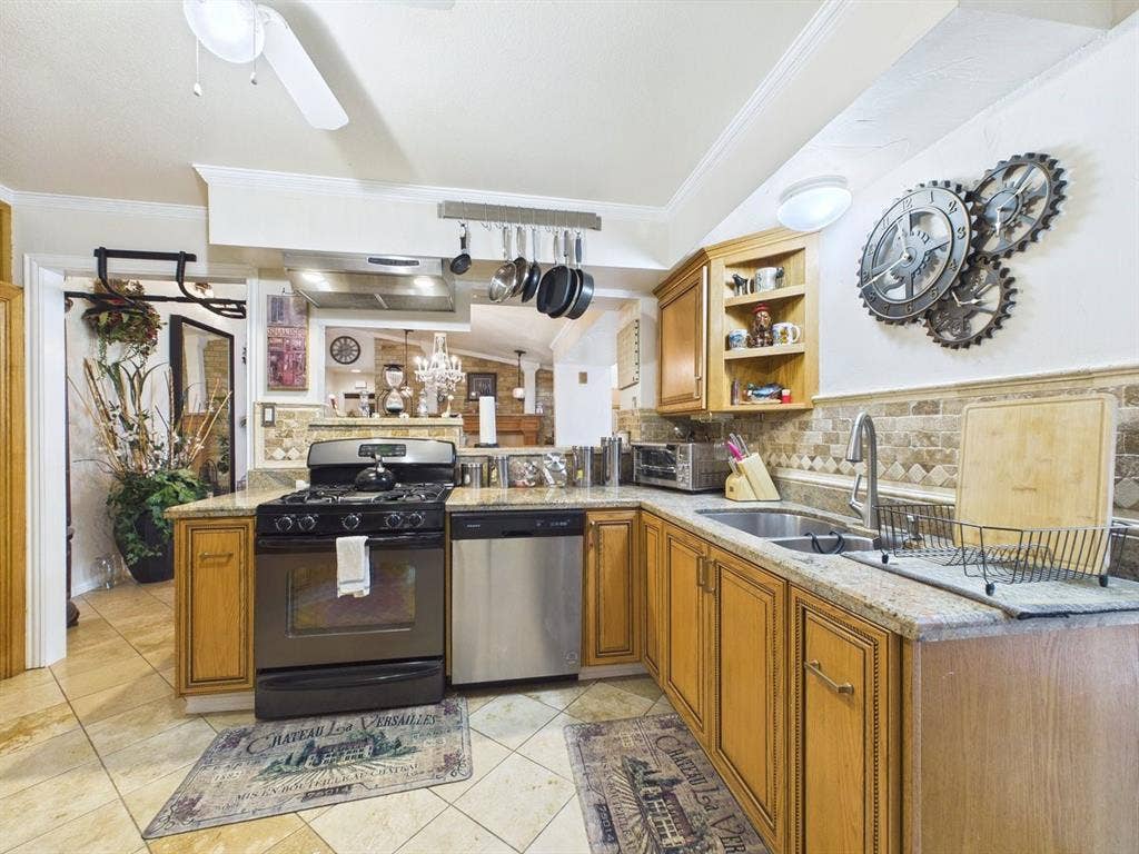 9335 Whittenburg Gate, Dallas, TX 75243 Kitchen featuring granite countertops, wood cabinetry, stainless steel dishwasher, gas range, and tile flooring