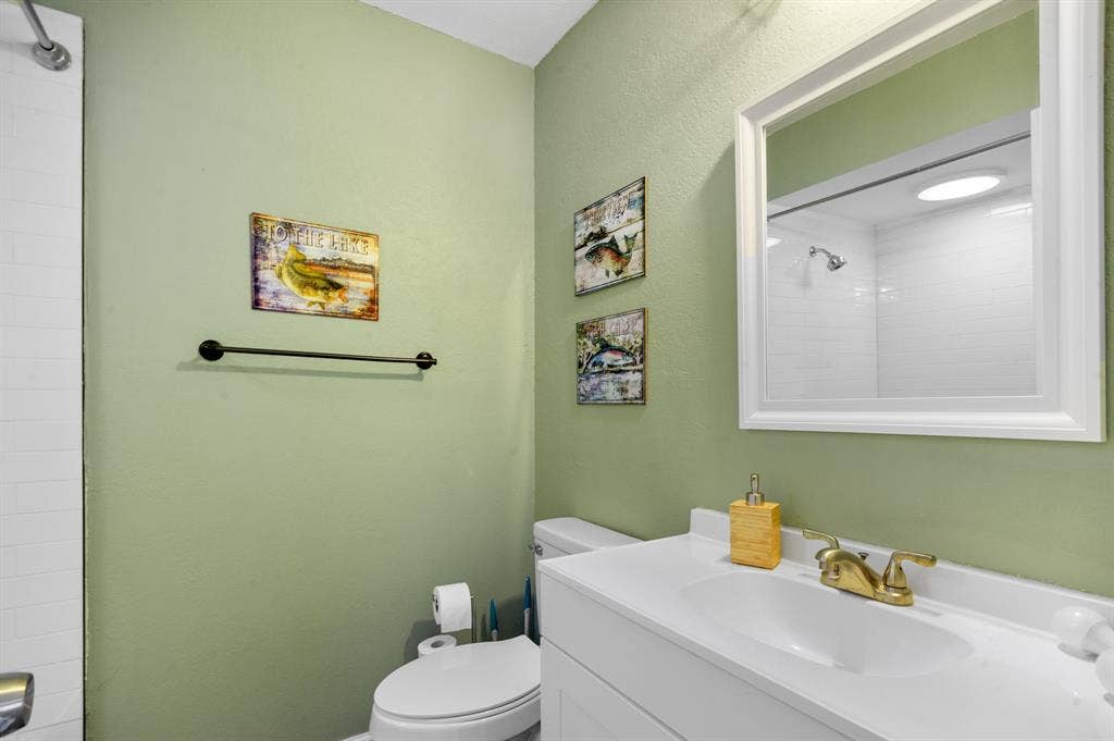 Irving, TX 75060 Vanity with integrated sink, gold-finish faucet, and coordinating framed mirror
