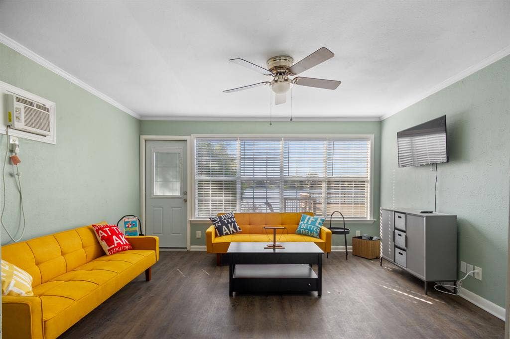 Irving, TX 75060 Expansive living area with wood-finish flooring, a ceiling fan, and large windows with blinds