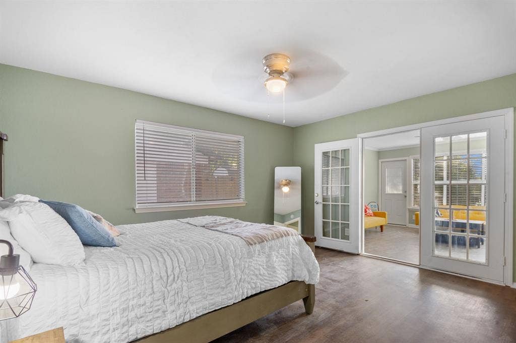 Irving, TX 75060 Wood-finish flooring, ceiling fan with integrated lighting, window with horizontal blinds, and double glass-paned doors