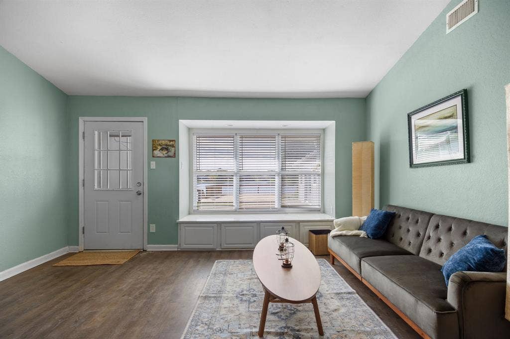 Irving, TX 75060 Wood-finish flooring, light green wall finishes, and a window with blinds and built-in storage