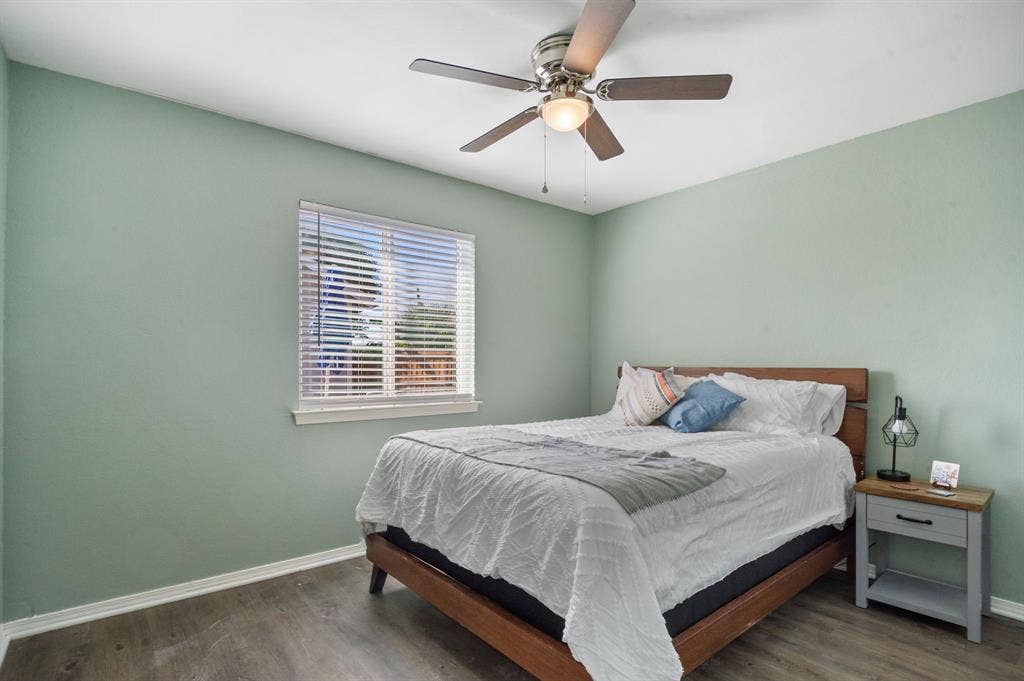 Irving, TX 75060 Wood-finish flooring, ceiling fan with integrated lighting, window with blinds, and light-toned wall paint