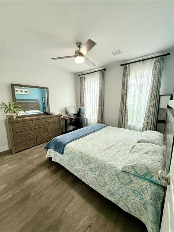 Ceiling fan with integrated lighting, wood-finish flooring, and white walls