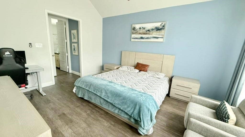 Vaulted ceiling with recessed lighting, wood-finish flooring, two-tone wall paint, and a built-in closet