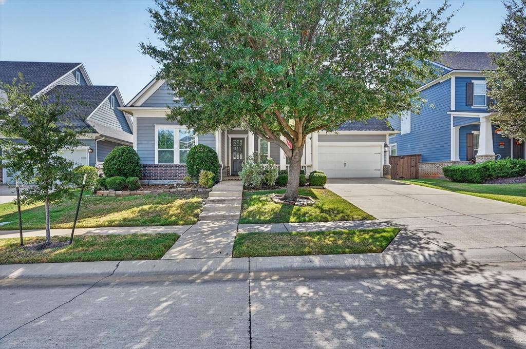 Charming two-story home with a welcoming front facade featuring blue exterior siding and a two-car garage