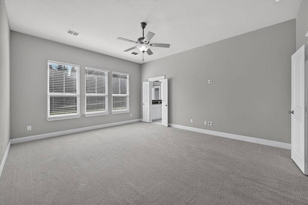 Carpeted room featuring a vaulted ceiling and a ceiling fan with integrated lighting