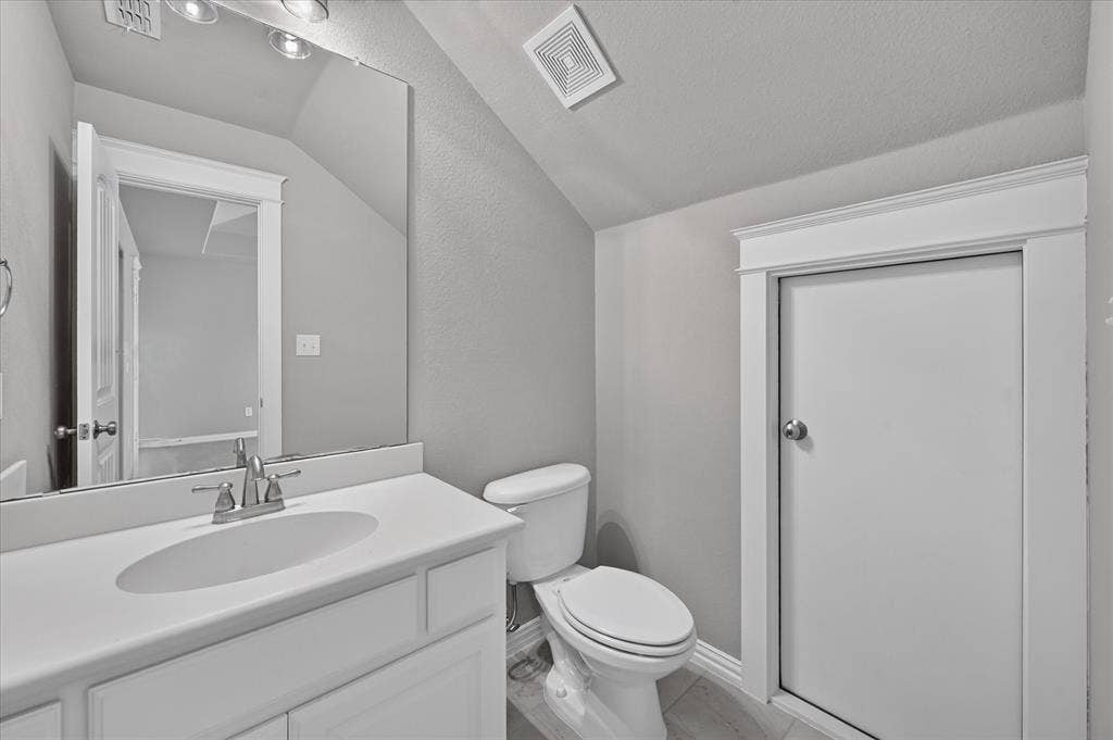 Vanity with an integrated sink, brushed nickel faucet, and overhead lighting
