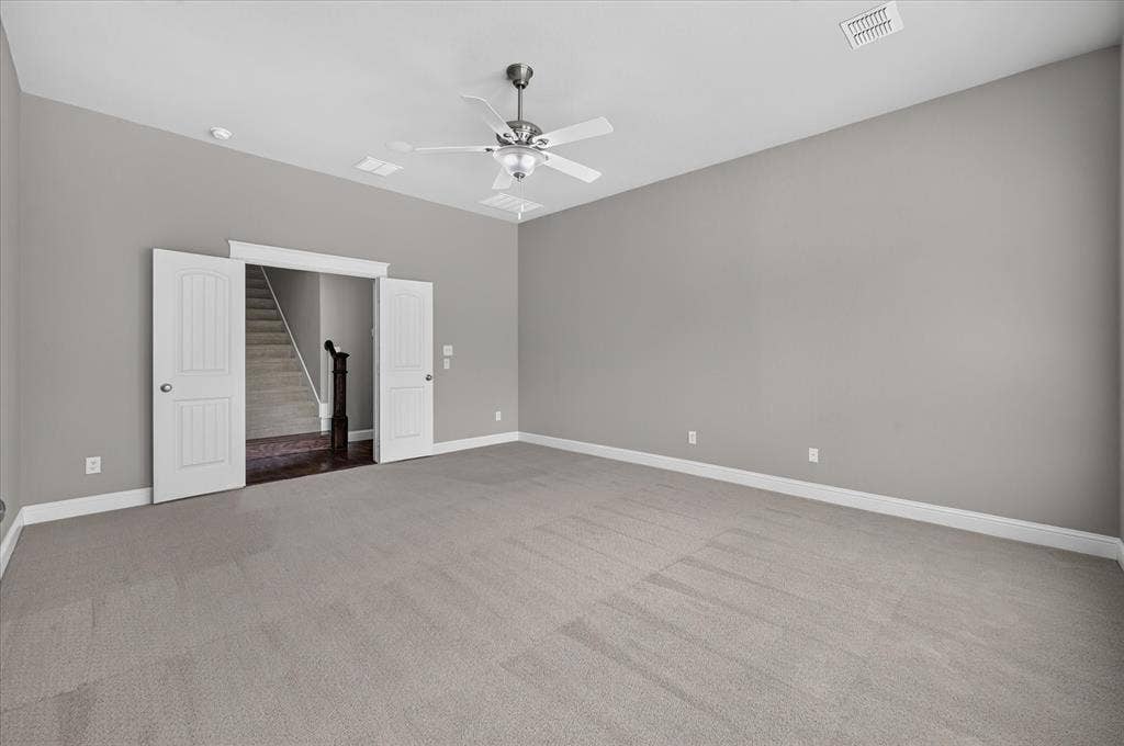 Spacious room with light gray carpeting and walls