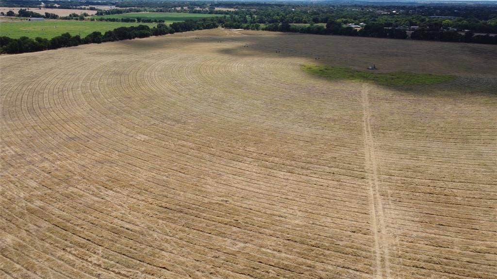 Expansive agricultural land featuring a track and varied terrain