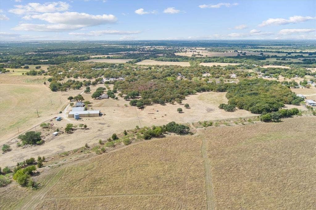 Expansive acreage with scattered mature trees and open fields