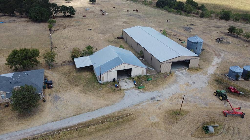 Expansive property featuring multiple outbuildings, including a large metal barn with an open bay