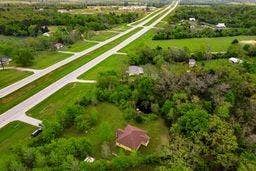 12770 E US 175 E, Larue, TX 75770 Aerial perspective of a property featuring extensive wooded acreage, a cleared lawn area, and a structure with a multi-faceted roofline