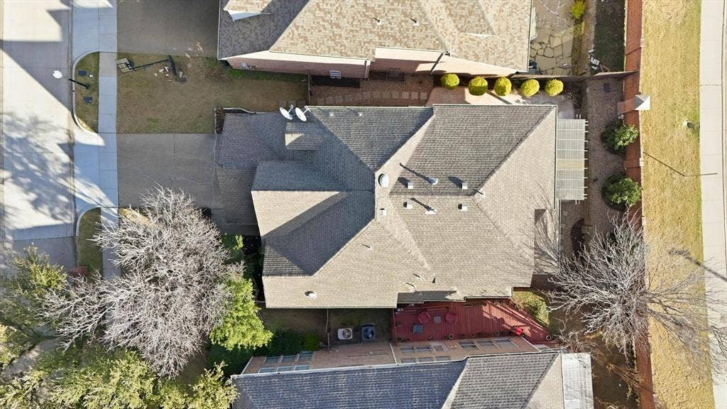 2917 Waterford Drive, Irving, TX 75063 Pitched roof with shingles, paved driveway, landscaped front yard, and a covered patio area