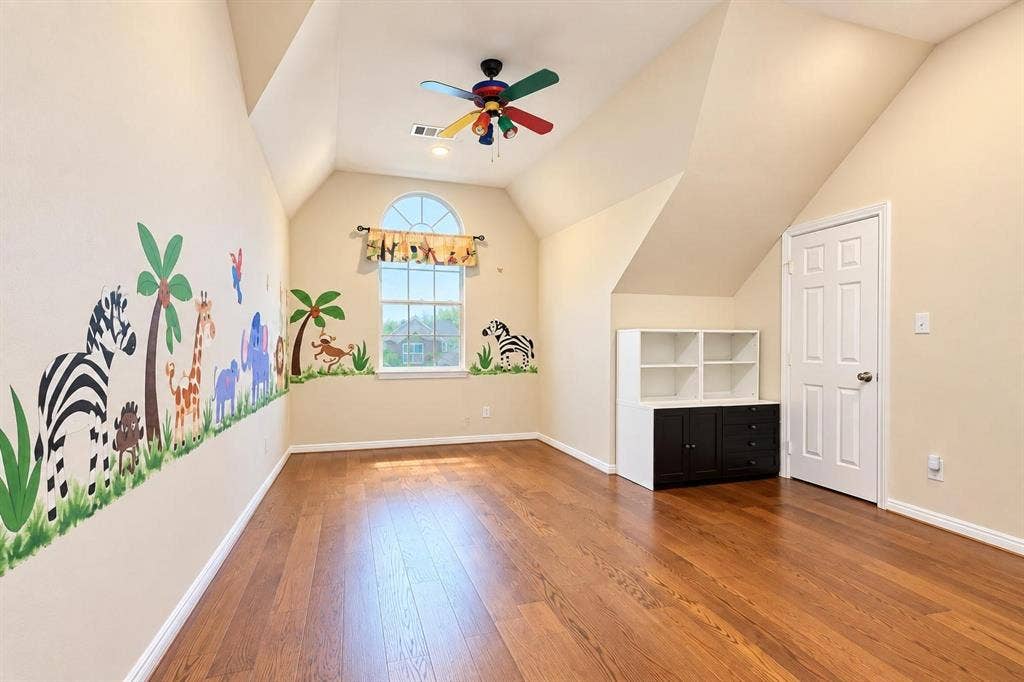 2917 Waterford Drive, Irving, TX 75063 Hardwood flooring with a built-in storage unit, an arched window, and a colorful ceiling fan