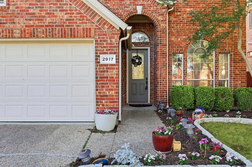 2917 Waterford Drive, Irving, TX 75063 Brick exterior, arched entryway, arched window, shrubbery, landscaped garden beds