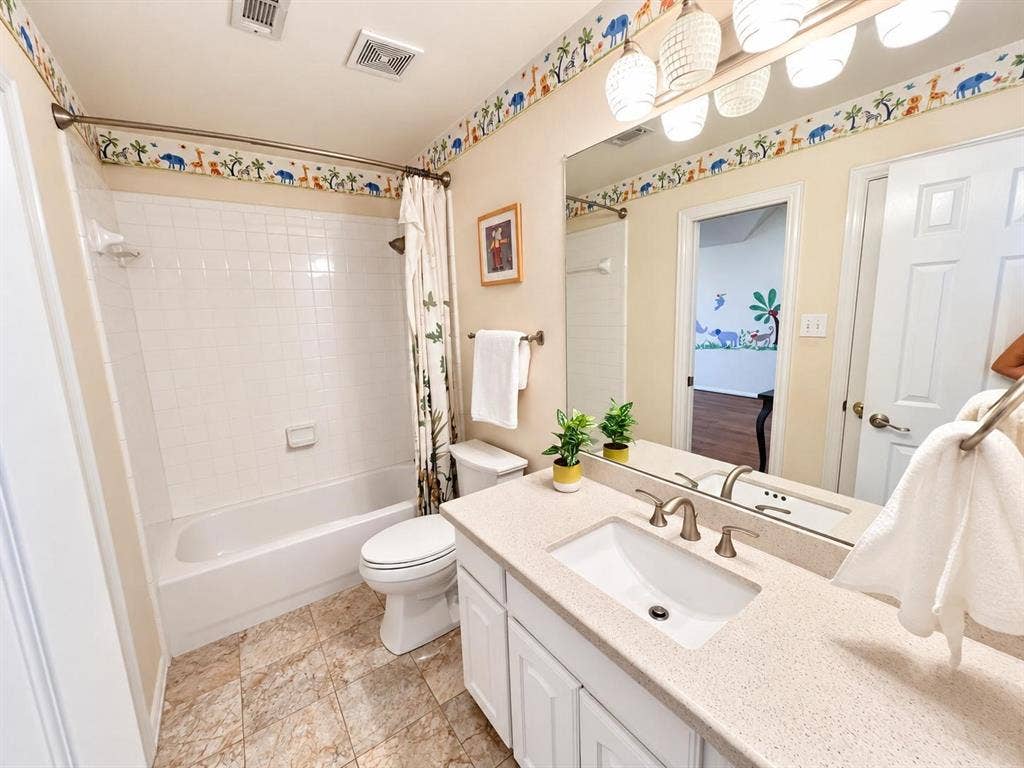 2917 Waterford Drive, Irving, TX 75063 Bathroom featuring a single vanity with an integrated sink, brushed nickel faucet, large wall mirror, and overhead lighting