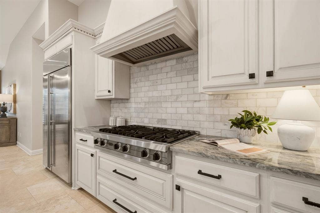 1120 Twin Oaks Drive, Prosper, TX 75078 A full compliment of stainless appliances include: a built-in refrigerator, commercial grade 6-burner Viking gas cooktop, double ovens, a microwave.