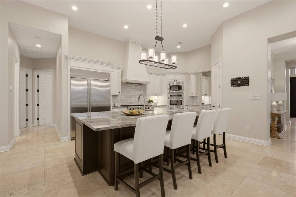 1120 Twin Oaks Drive, Prosper, TX 75078 This impressive kitchen is a true centerpiece of the home, featuring decorator lighting, hardware + a massive center island that offers ample room for meal prep, casual dining & gathering of friends.