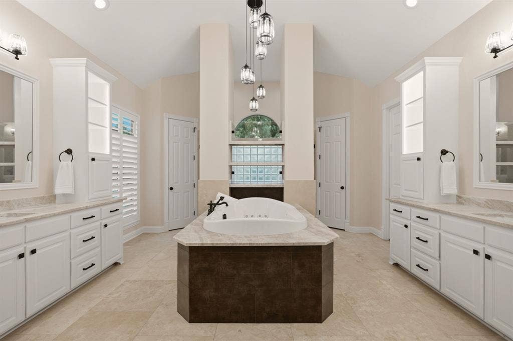 1120 Twin Oaks Drive, Prosper, TX 75078 The remodeled primary bath is defined by clean lines & thoughtfully chosen finishes. Fusion Quartzite countertops adorn the vast amount of cabinets. Noteworthy tiered pendant lighting over the deep Jetta Jacuzzi luxury spa tub with hydro & action jets. A true spa experience! His & hers walk-in closets too.