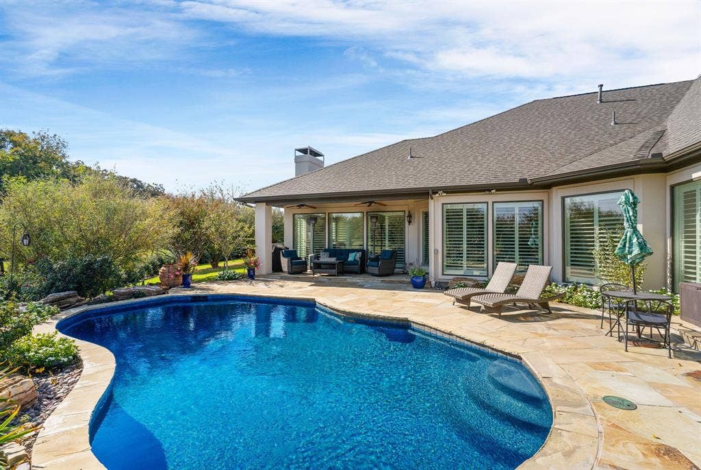 1120 Twin Oaks Drive, Prosper, TX 75078 For those who love a backyard pool, this one is deep on the far end +...you'll appreciate the generous open & covered patio space for multiple lounging areas or dining under the open sky. Windows expand all along this side of the home to capture the allure of the glimmering swimming pool.