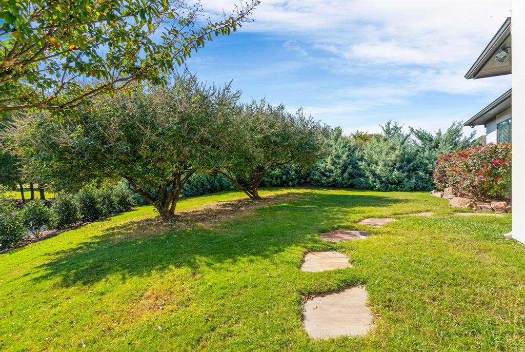 1120 Twin Oaks Drive, Prosper, TX 75078 One of two grassy areas for kids & pets to play. This photo also shows some of the native Texas trees, hedges, flowers that offer privacy & color all year long.