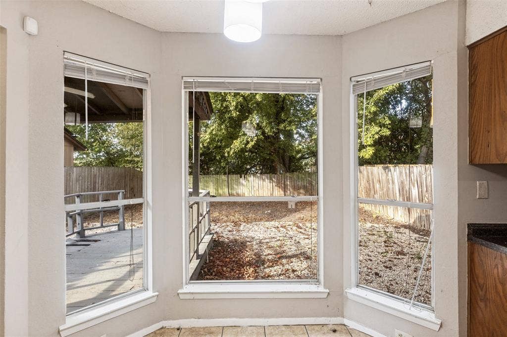 12206 Tyson Cove, #A, Austin, TX 78758 Bay window with three paneled windows, tiled flooring, wood cabinetry, and dark countertops