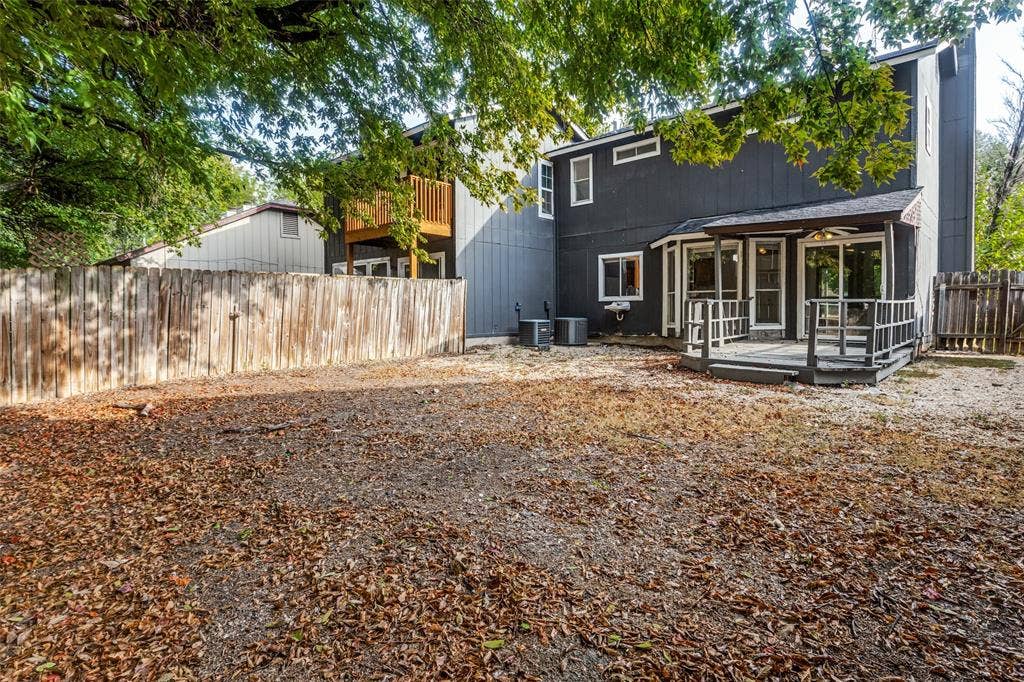 12206 Tyson Cove, #A, Austin, TX 78758 Expansive backyard featuring a privacy fence, covered patio deck, and a second-story wooden balcony