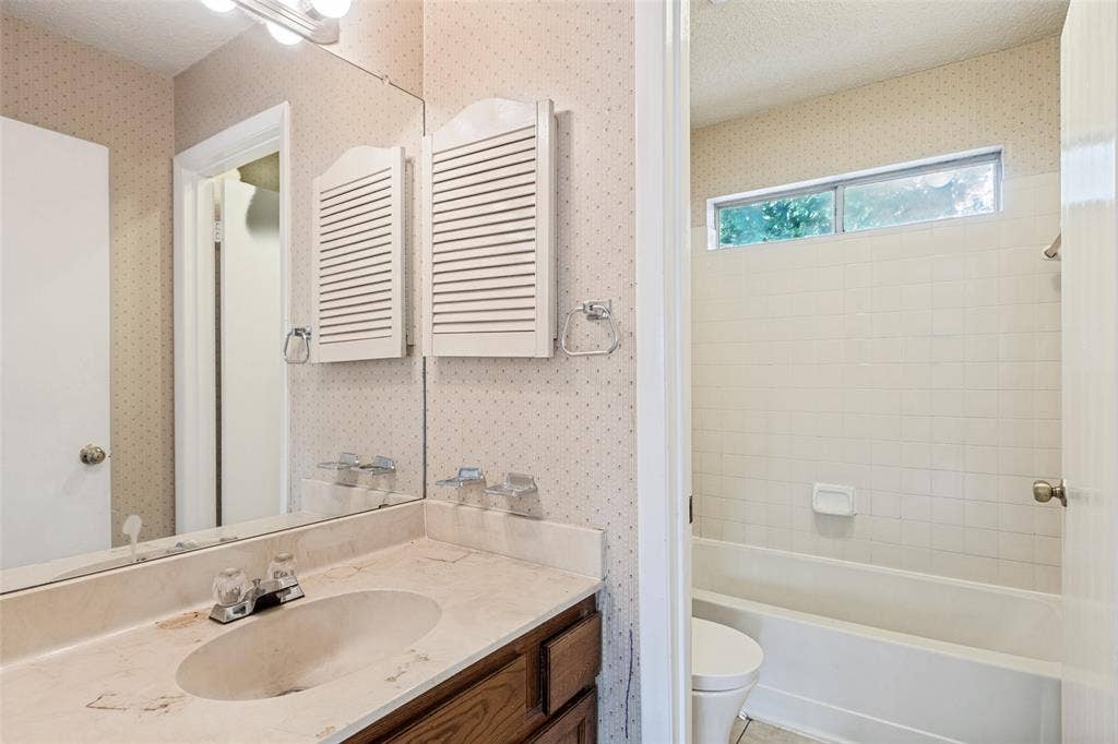 12206 Tyson Cove, #A, Austin, TX 78758 Bathroom vanity with an integrated sink, wood-finish cabinetry, and a vanity mirror