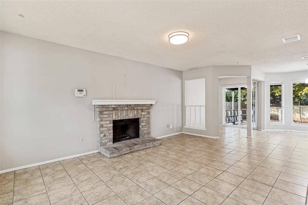 12206 Tyson Cove, #A, Austin, TX 78758 Stone brick fireplace with hearth, tile flooring, recessed lighting, and multiple windows