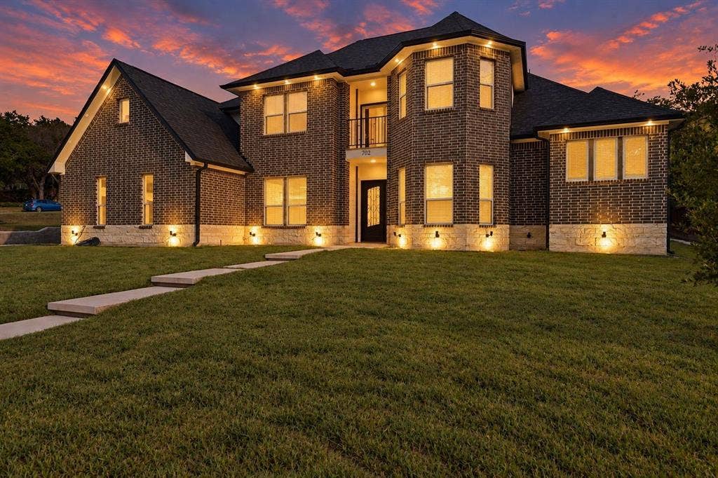 702 Linkcrest Drive, Duncanville, TX 75137 Two-story brick facade with stone accent detailing, multiple windows, and a prominent front entry