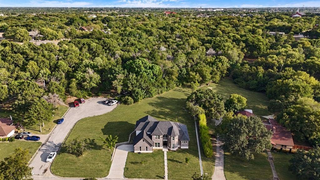 702 Linkcrest Drive, Duncanville, TX 75137 Stone and brick exterior with a multi-gabled roof, expansive green lawn, and concrete driveway
