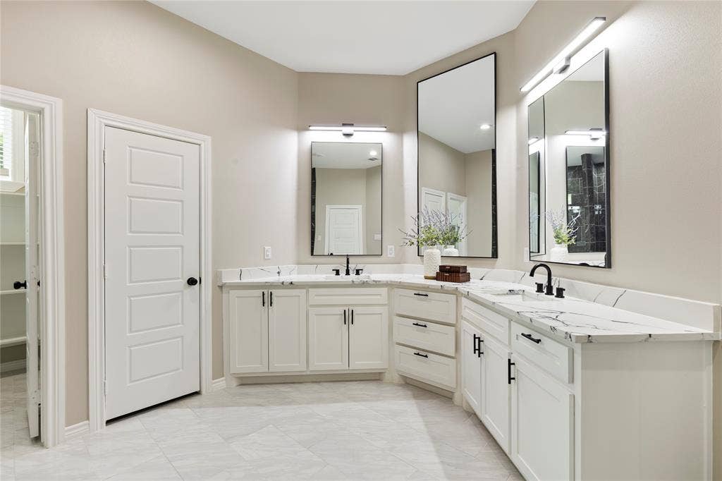 702 Linkcrest Drive, Duncanville, TX 75137 Dual vanities with white cabinetry, integrated sinks, and black fixtures