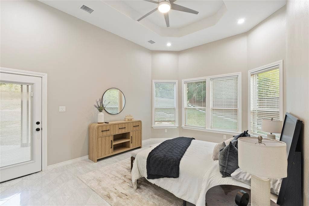 702 Linkcrest Drive, Duncanville, TX 75137 Tray ceiling with recessed lighting and ceiling fan, multiple windows with blinds, glass-paneled exterior door, and tile flooring
