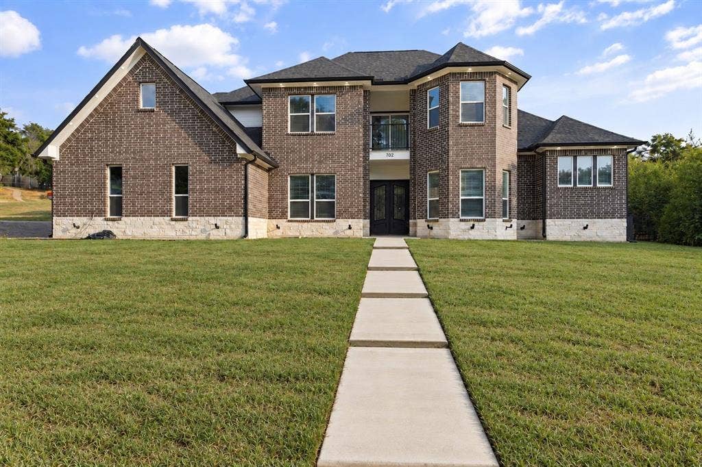 702 Linkcrest Drive, Duncanville, TX 75137 Brick exterior with stone accents and dark-framed windows