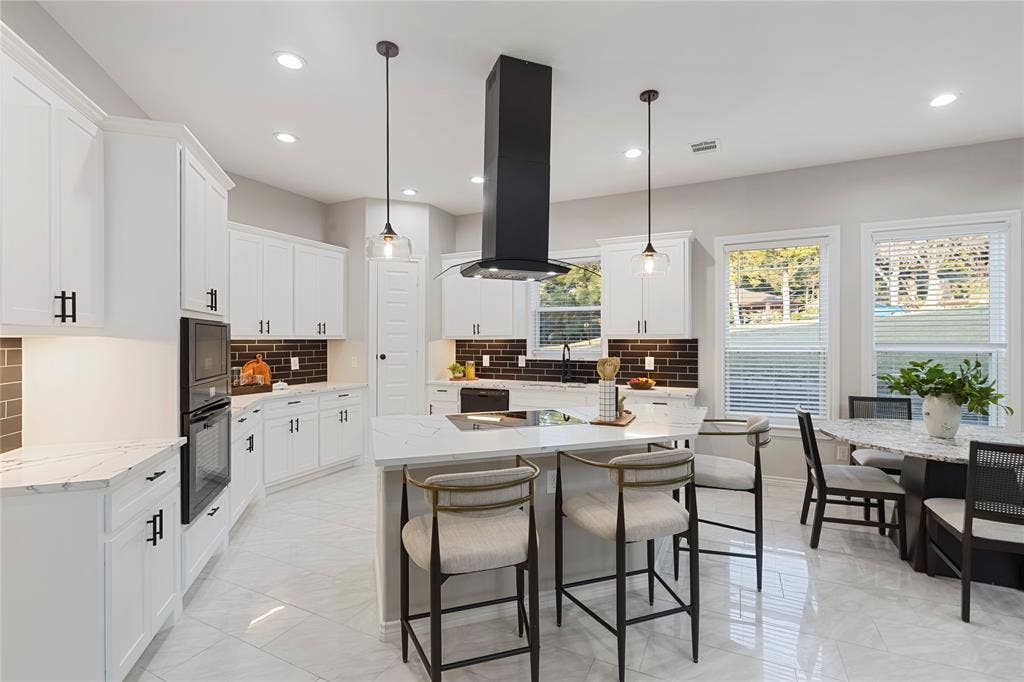 702 Linkcrest Drive, Duncanville, TX 75137 White cabinetry with black hardware, stone countertops, and a dark brick-patterned backsplash