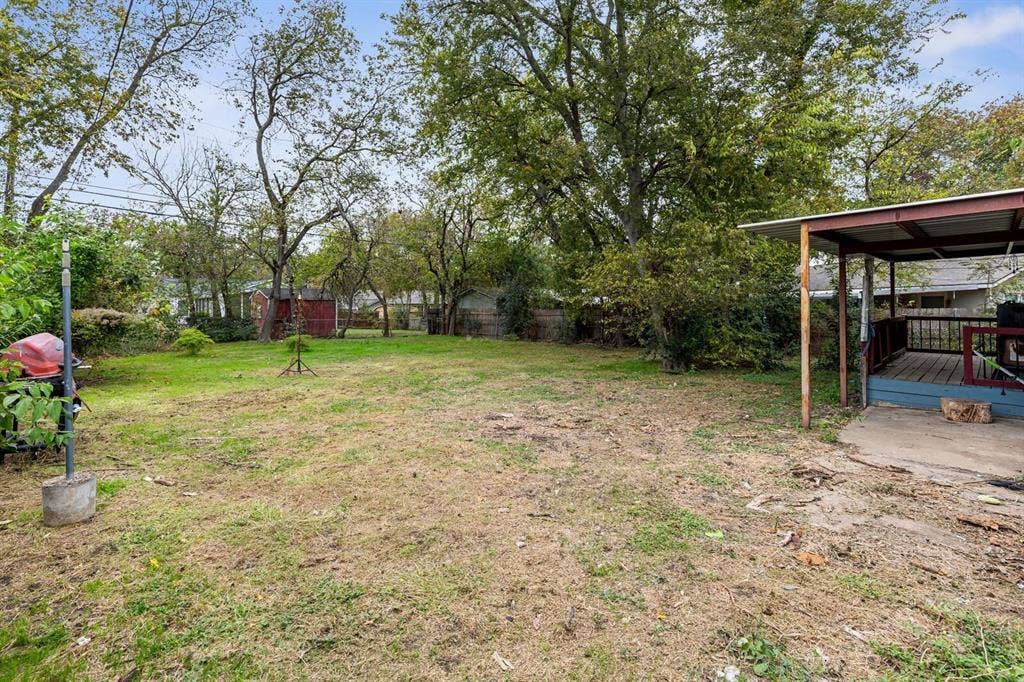 4205 Fort Avenue, Waco, TX 76710 Expansive yard space featuring mature trees and a covered patio with a wood-plank deck