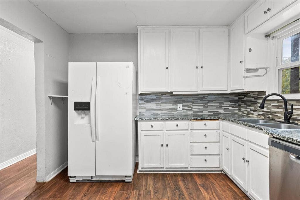4205 Fort Avenue, Waco, TX 76710 Updated kitchen featuring white cabinetry, granite-style countertops, mosaic tile backsplash, stainless steel sink, and wood-finish flooring