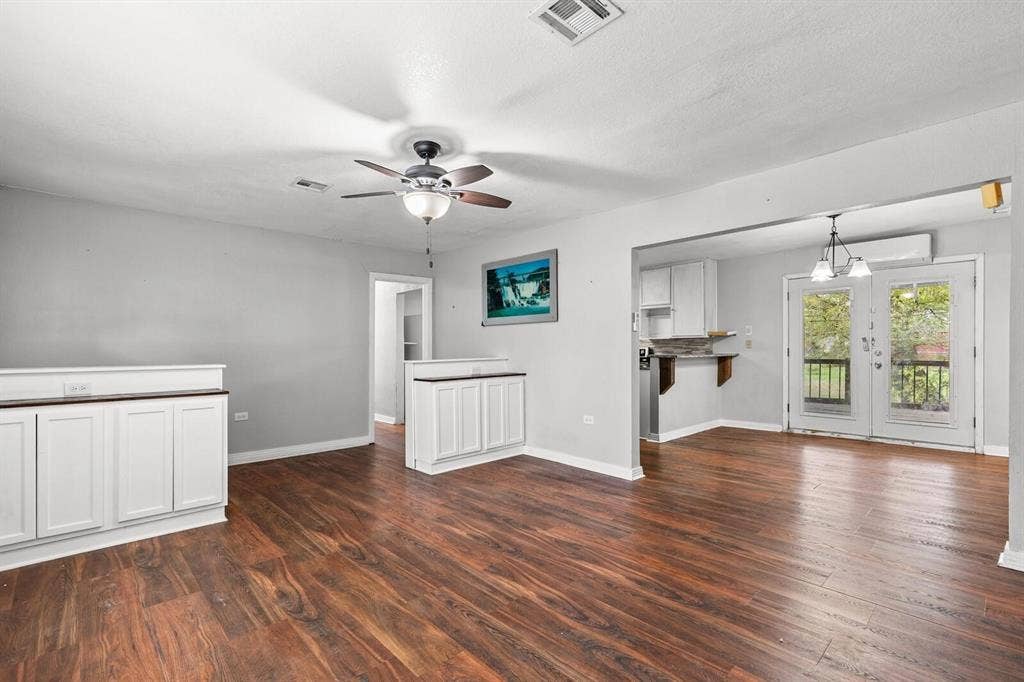 4205 Fort Avenue, Waco, TX 76710 Wood-finish flooring throughout, white cabinetry with wood-tone countertops, ceiling fan, and double glass doors opening to the exterior