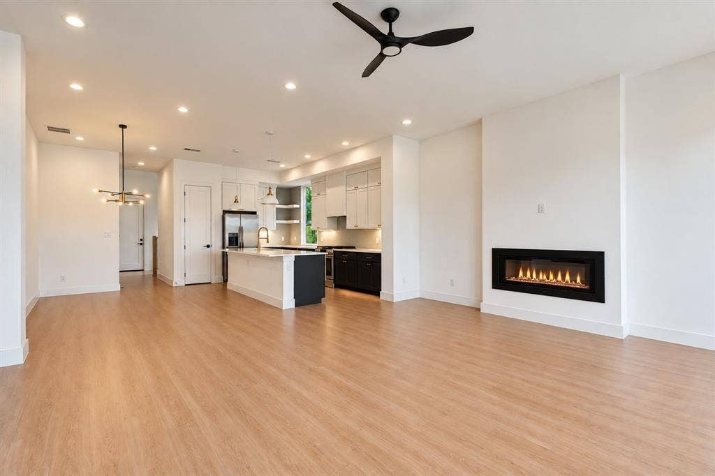 314 Avenue L, Dallas, TX 75203 Open-concept living area featuring wood-finish flooring, a linear electric fireplace, and recessed lighting